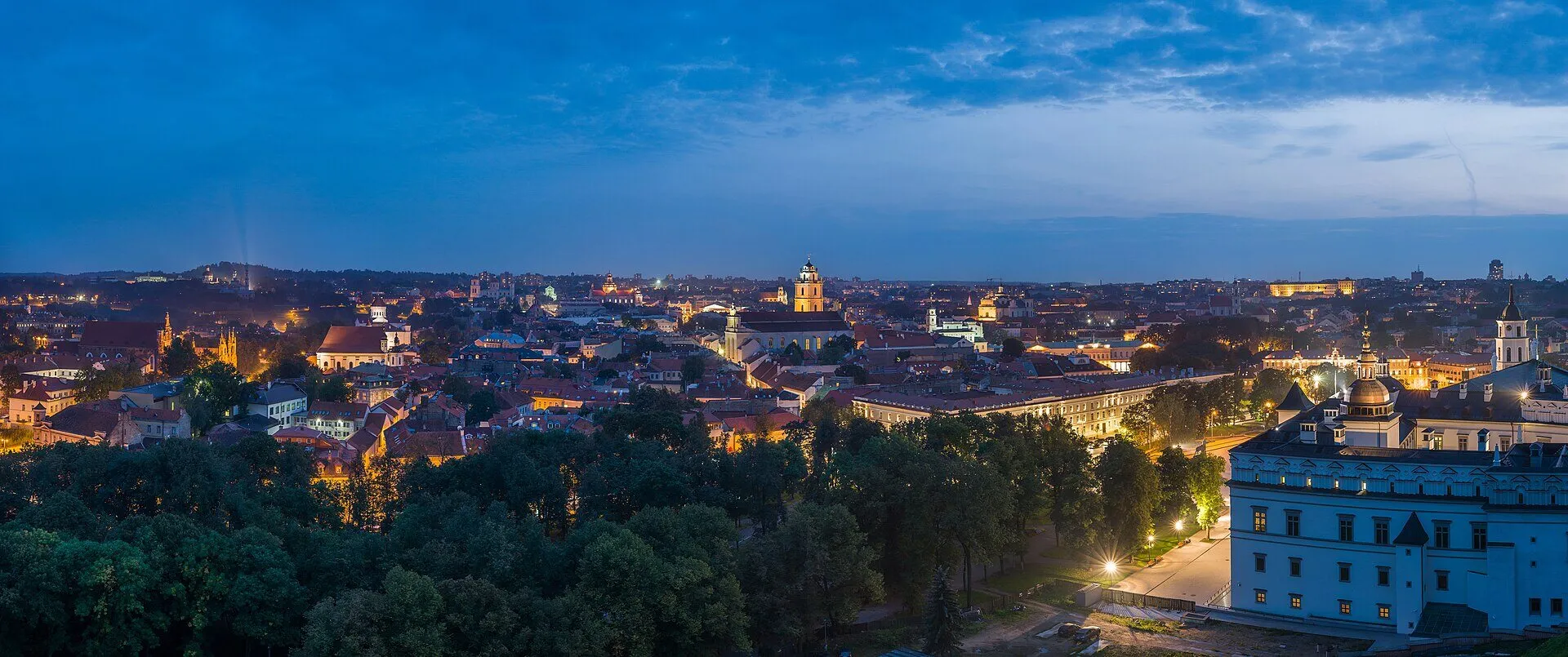 Vilnius Old Town skyline at dusk, with baroque churches and red rooftops